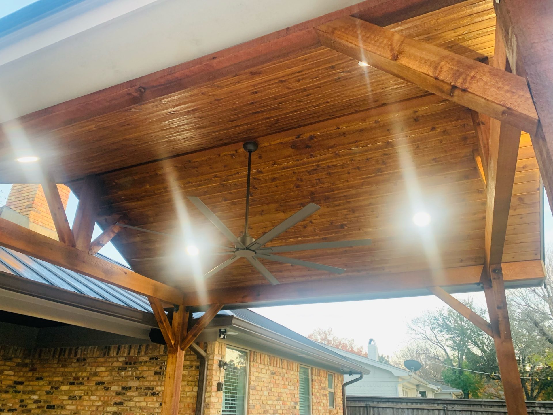 Professional outdoor pavilion patio cover build in Arlington, TX by Jenkins roofing with ceiling fan and custom ceiling lighting