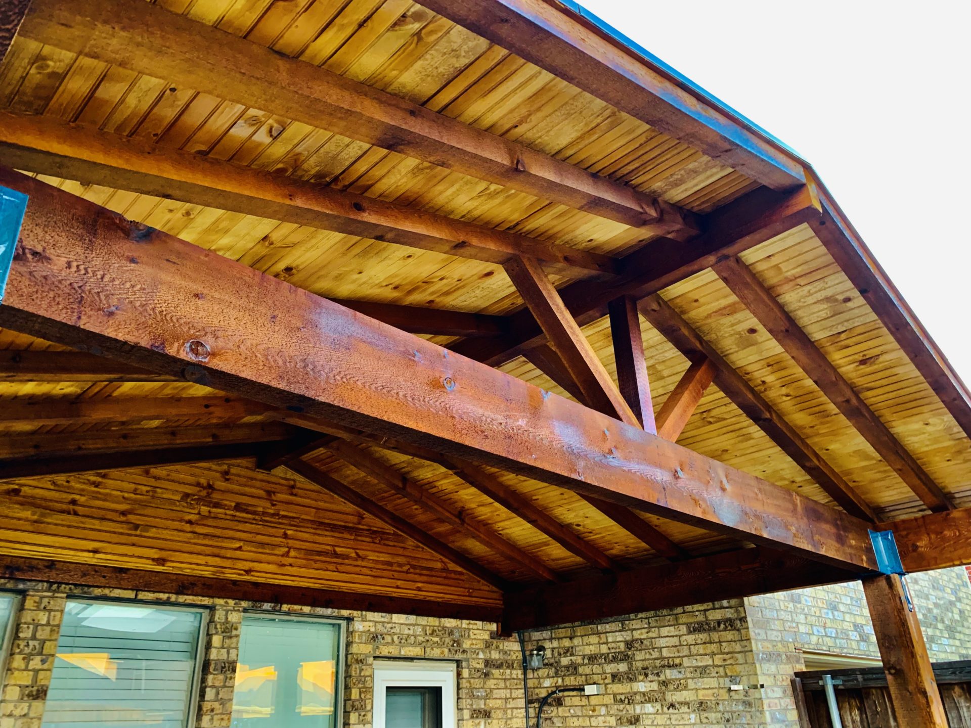 Underneath pavilion patio styled roof with beautiful wooden cross beams.
