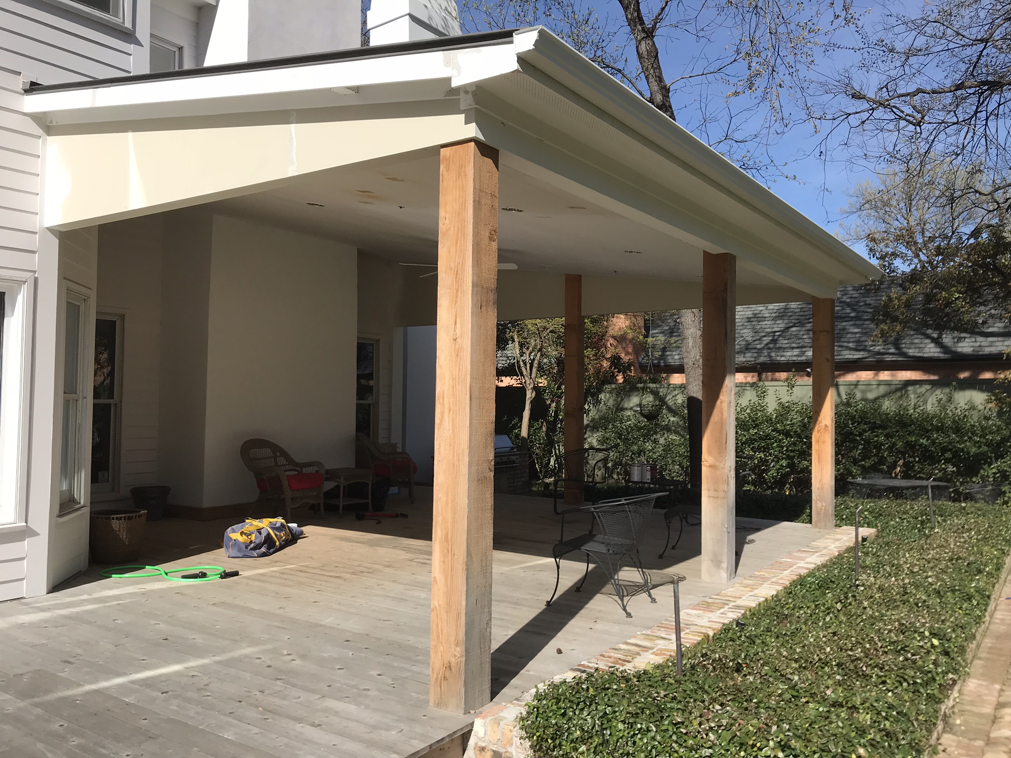 Home in North Texas with large backyard patio area that is covered with patio roof built by Jenkins Roofing.