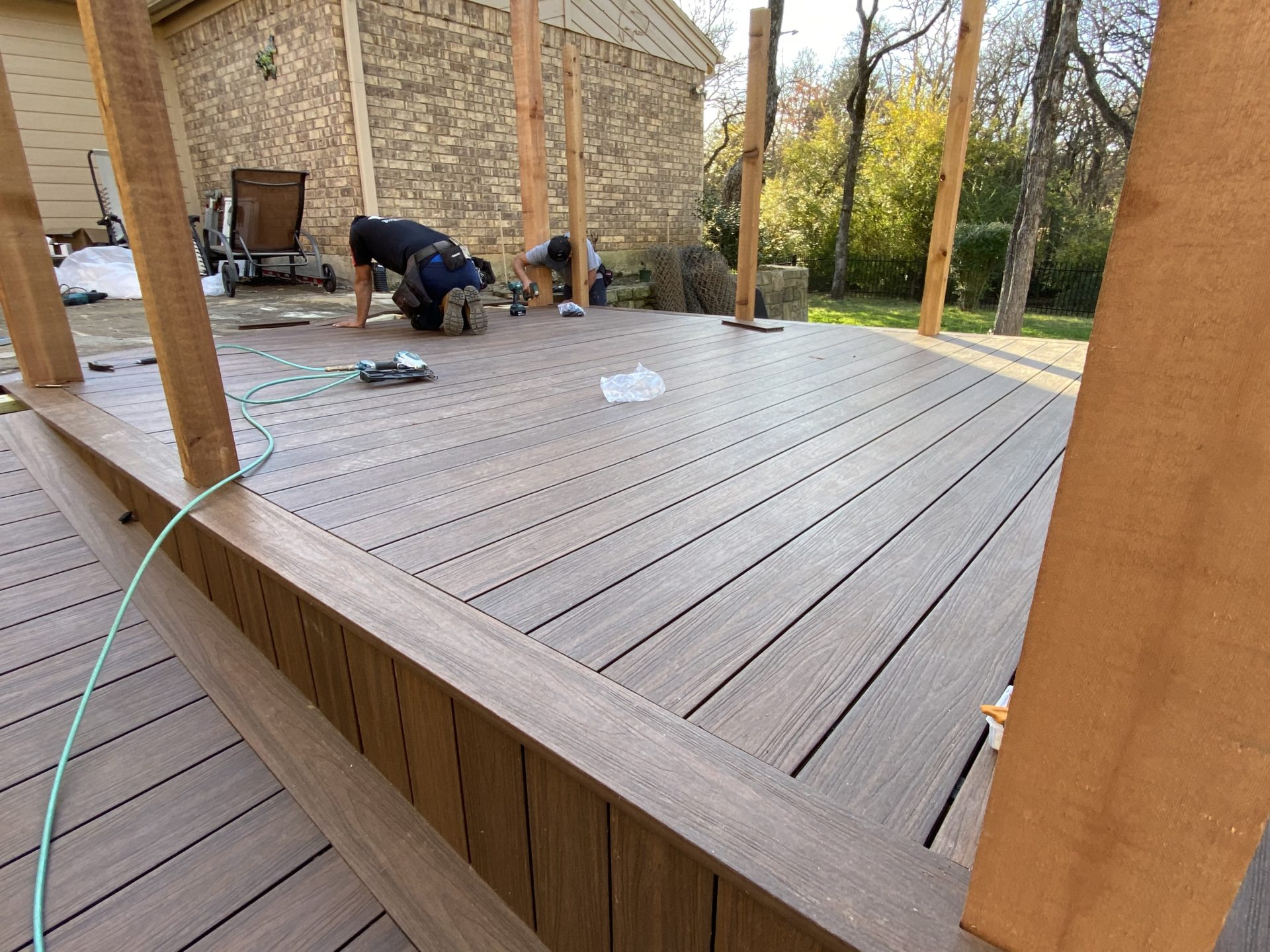 Jenkins Roofing team working on a custom backyard deck with wooden floor in Arlington, TX