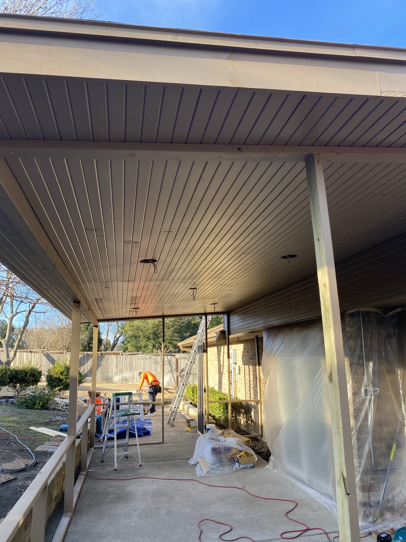 Patio builders from Jenkins Roofing working on patio project in Arlington, Texas with custom roof lighting