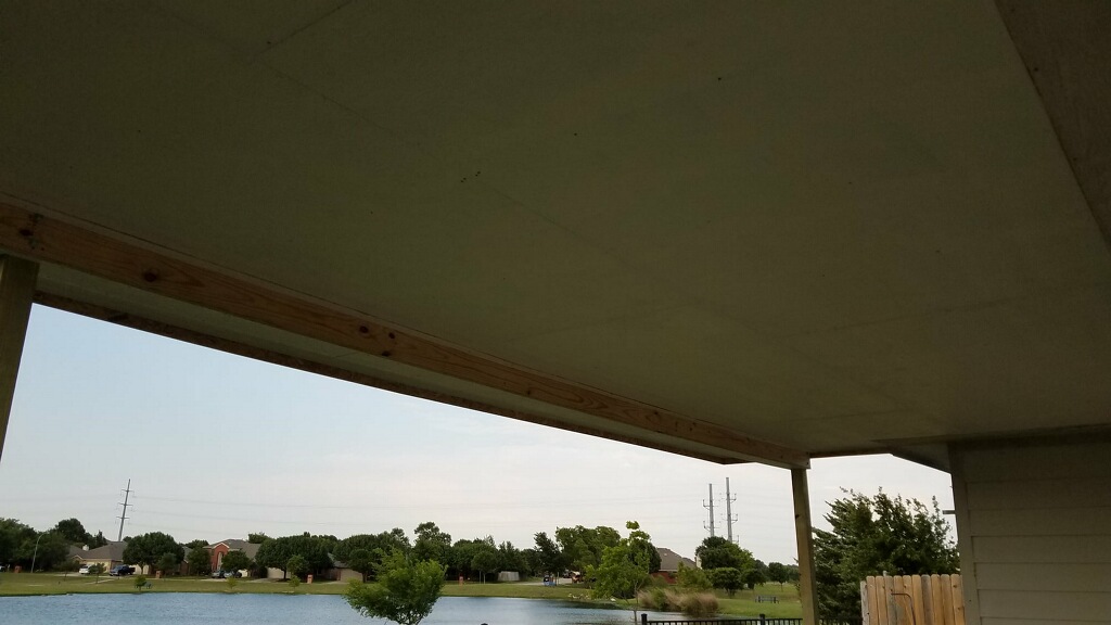 Underside of patio roof with backyard view of lake in North Texas.